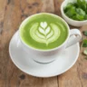 Tasse de matcha latte décorée d’un motif floral latte art sur table en bois