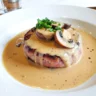 Tournedos de bœuf nappé de sauce aux morilles onctueuse, avec champignons fondants et crème légère.