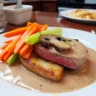 Blanquette de veau servie avec carottes fondantes, poireaux et champignons de Paris.